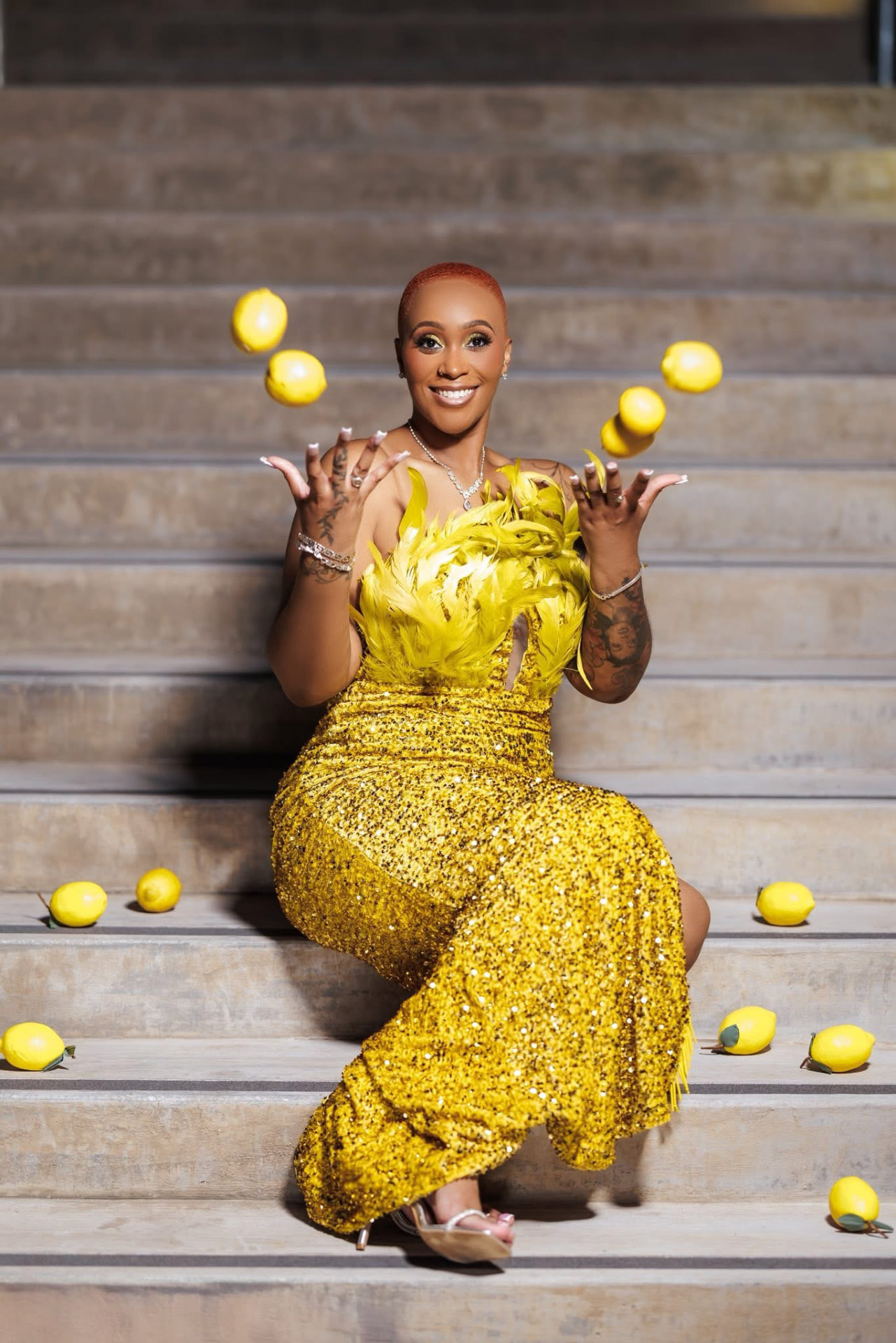 Jamie Gainey in a yellow sequin gown tossing lemons on the steps